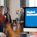 Group of colleagues discussing digital marketing strategies in an office setting.